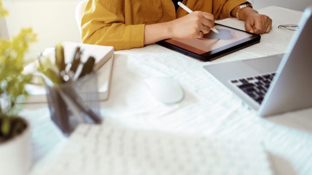 A person sitting at a desk with a laptop and pen