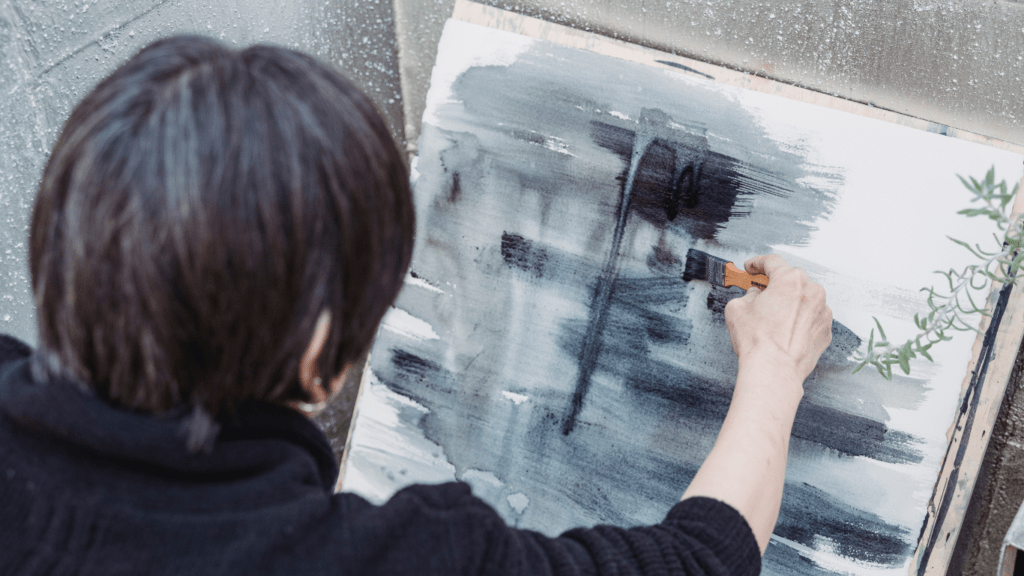 a person is painting on a canvas with a brush