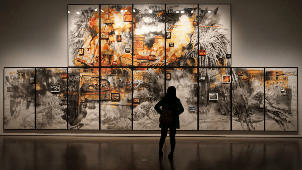 a person standing in front of a large painting