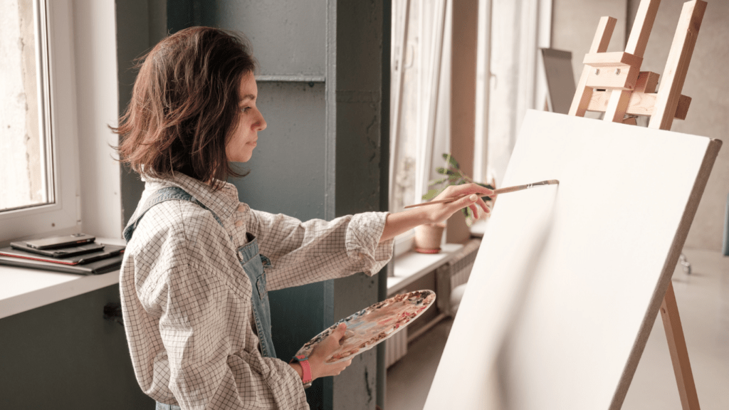 a person is painting on an easel in an art studio