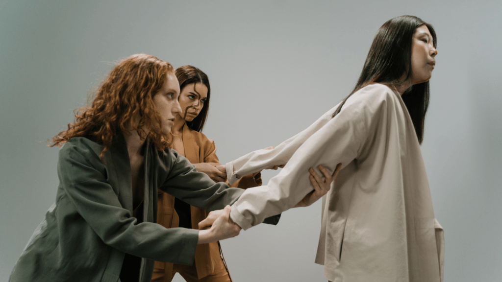 people are holding each other's hands while standing in front of a gray background.