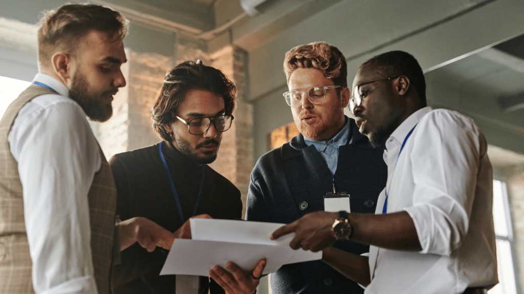 a group of business people talking to each other 