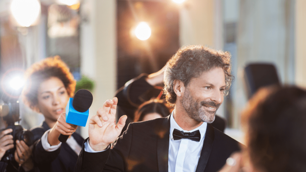 a person in a tuxedo talking to a reporter