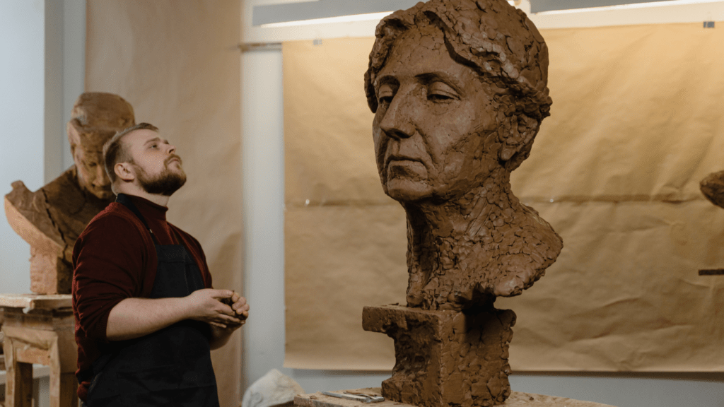 a person is working on a clay sculpture of a person