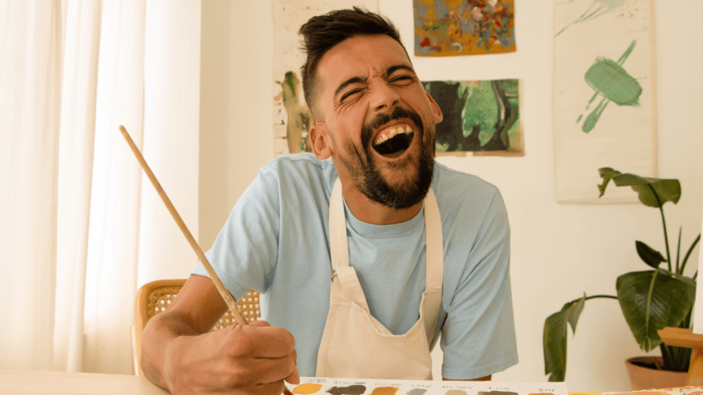 a person sitting at a table in front of a painting